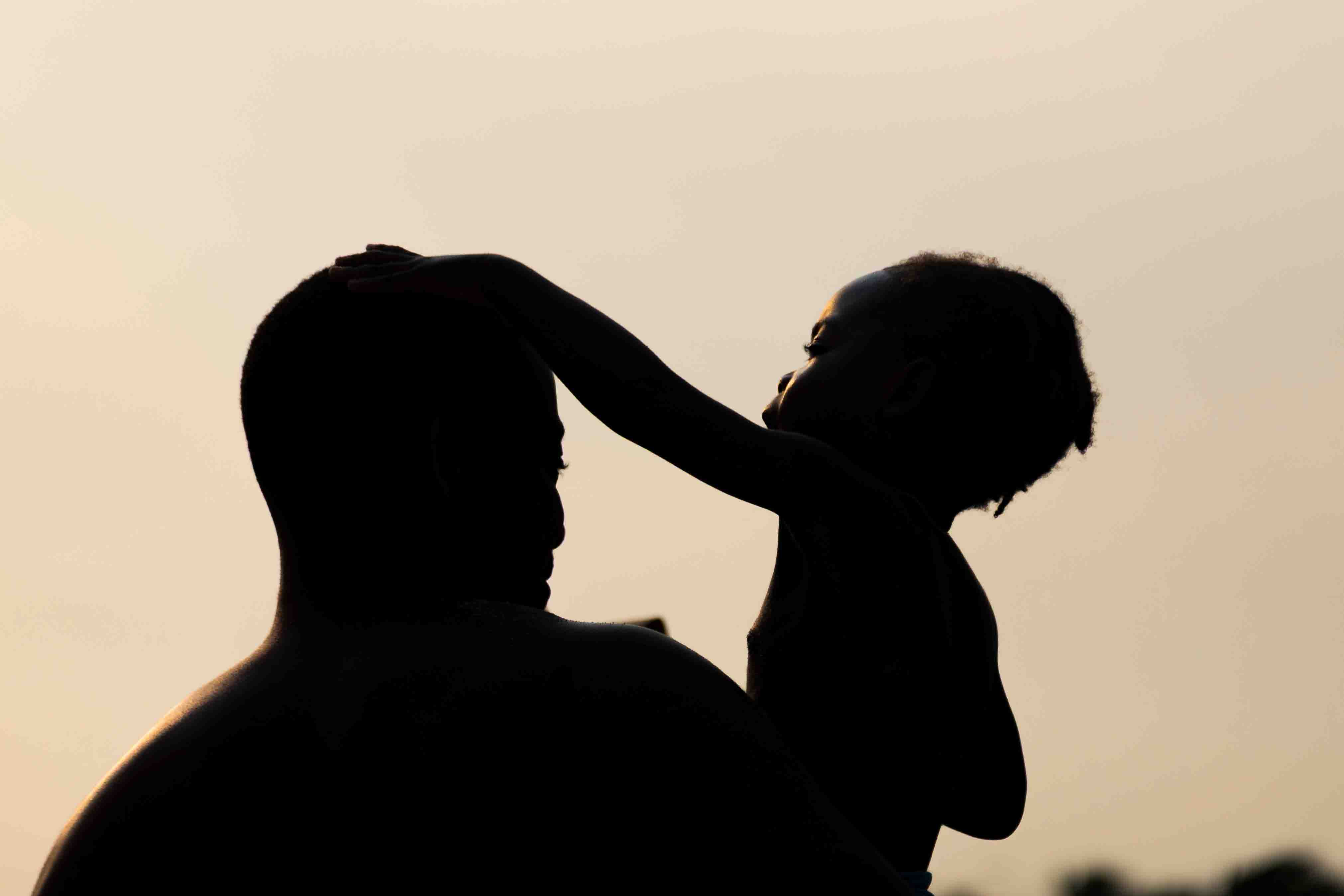 Silhouette of a person standing behind a bright orange sky